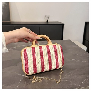 Detail of red and white striped straw bag with wooden handle and gold chain strap