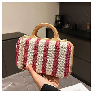 Detail of red and white striped straw bag with wooden handle and gold chain strap