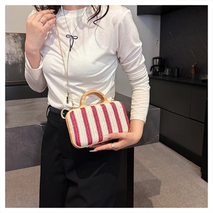 Detail of red and white striped straw bag with round wooden handle and gold chain strap