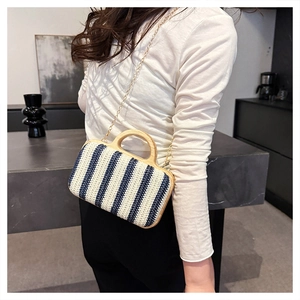 Detail of blue and white striped straw bag with round wooden handle and gold chain strap