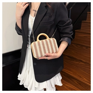 Detail showing woven stripe texture and semi-circular wood handle of the straw handbag