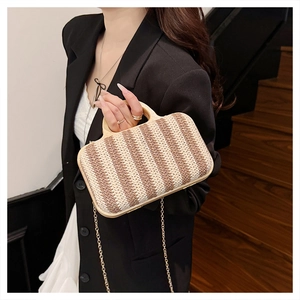 Detail of a striped straw handbag with wooden handle and gold chain strap for summer