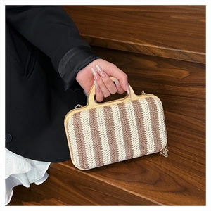 Detailed texture of hand-woven striped straw bag with round wooden handles for summer
