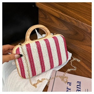 Detail of pink and white striped woven straw bag with wood handle and gold chain strap