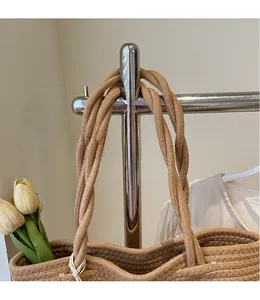 Detail of hand-woven tote bag showing twisted rope handles and natural fiber texture