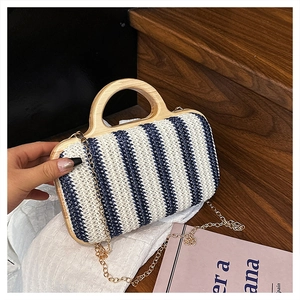 Close-up of blue striped straw bag featuring round wooden handle and gold chain strap