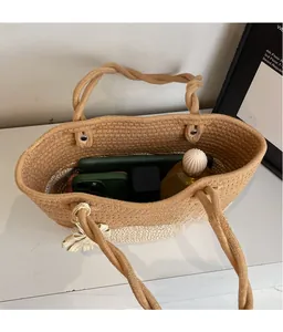 Detail of two-tone woven tote bag showing spacious interior and knot handle with bow