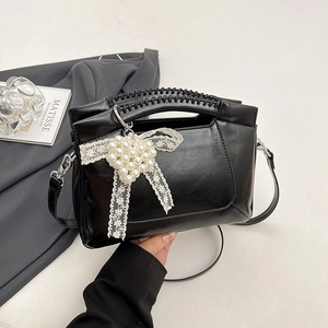 Chic black PU leather shoulder bag with woven handle and pearl heart bow charm detail