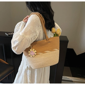 Detail of woven tote bag with brown and beige texture and purple flower charm
