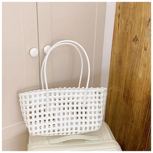 Détail montrant le motif de tissage évidé du sac à main tressé blanc élégant