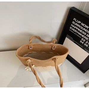Close-up of woven tote bag showing two-tone contrast stitching and interior space