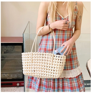 Détail d'un sac à main tissé ajouré crème avec texture à mailles larges et anses rondes