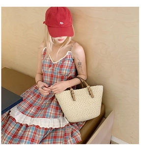 Chic beige woven handbag paired with a plaid lace dress and red baseball cap look