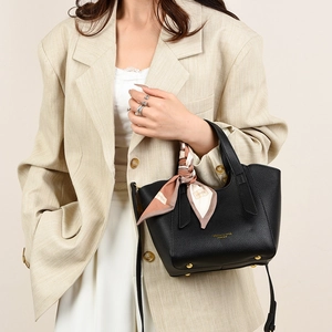 Detail of black lychee leather tote bag with silk scarf and gold protective feet