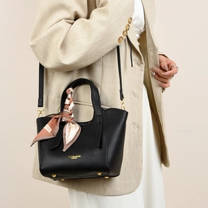 Detail of black lychee grain leather tote bag with printed silk scarf and gold hardware