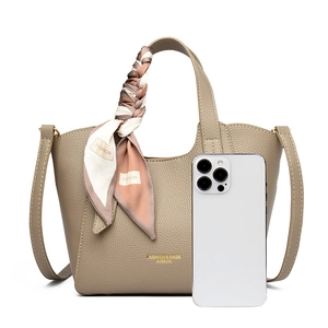Khaki pebbled leather handbag detail with silk scarf handle and phone for size reference