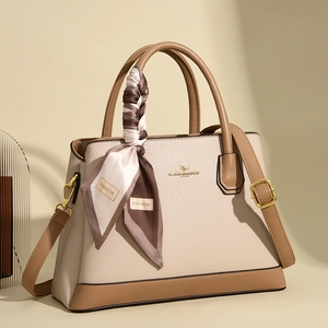 Close-up of beige lychee texture leather handbag with a floral silk scarf on the handle