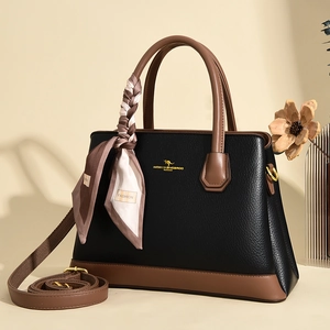 Detailed macro view of litchi texture leather handbag with kangaroo logo and silk scarf