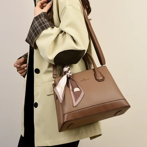 Brown litchi grain leather handbag with decorative silk scarf and adjustable strap