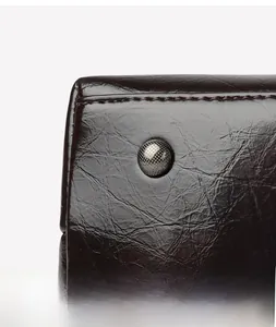 Vue détaillée du sac en cuir marron rétro avec double couture précise et rivet métallique