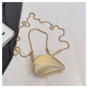 Detailed close-up of a golden shell-shaped evening clutch with fine radial texture and chain