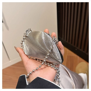 Detailed macro view of silver metallic shell-shaped clutch bag with beaded chain link