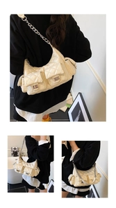 Close-up of cream quilted multi-pocket shoulder bag with metal chain strap