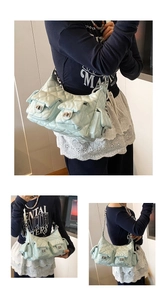 Detail of mint green quilted shoulder bag with multi-pocket design and silver chain strap