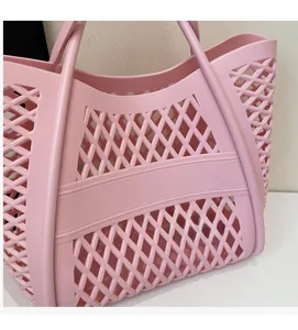 Gros plan d'un sac cabas rose ajouré en plastique avec motif quadrillé tissé et matériau