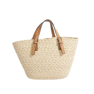 Minimalist woven handbag with brown leather handles and gold buckles for summer travel