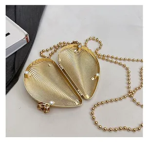 Macro view of golden heart-shaped clutch with magnetic closure and inner circular texture