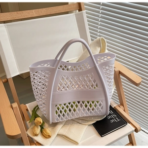 Vue détaillée d'un sac cabas ajouré blanc posé sur une chaise de jardin rustique