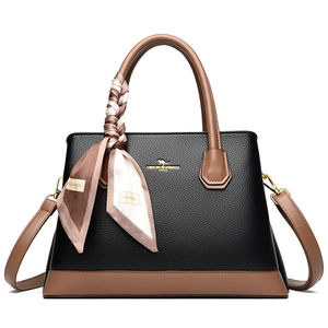 Litchi texture black handbag with brown straps and silk scarf on white background
