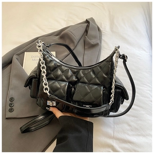 Detail of black quilted underarm bag with silver chain and multiple pockets design