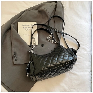 Top view of black quilted faux leather shoulder bag with silver chain and side pockets