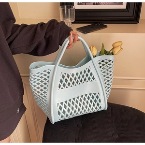 Détail du sac cabas en maille bleu clair avec motifs losanges et doubles poignées