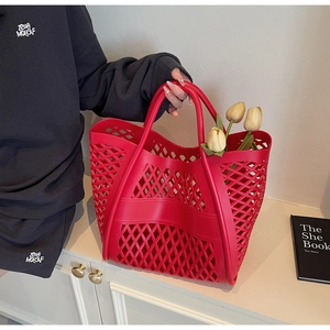 Vue détaillée d'un sac à main rouge tressé avec maille évidée et poignées souples