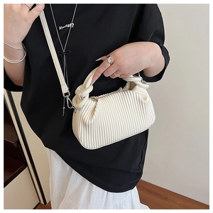 Close-up of white pleated handbag featuring vertical texture and knotted top handle