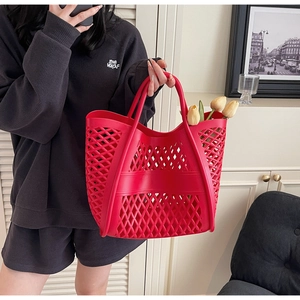 Vue détaillée du sac cabas rouge vif au design géométrique ajouré avec poignées intégrées