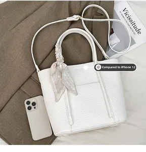 Size comparison of white lychee leather tote bag with iPhone 12 and silk scarf detail