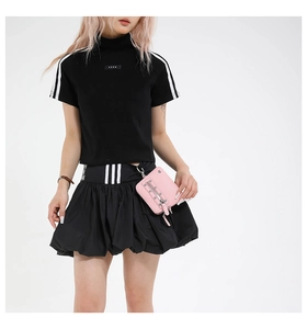 Detail of black sporty pleated skirt and matching pink mini pouch with white stripes