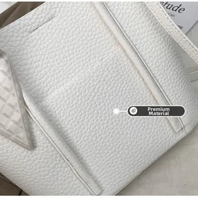 Close-up of white lychee grain leather tote bag with decorative patterned silk scarf
