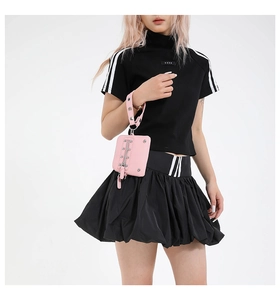 Detail of pink pebbled leather wristlet with vertical metal zipper and grommet strap