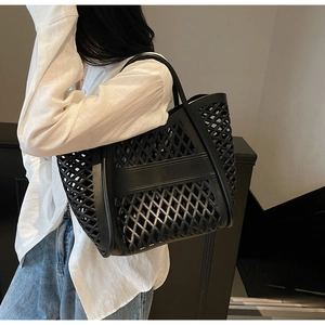 Détail du sac cabas ajouré noir avec motif de losanges et poignées robustes