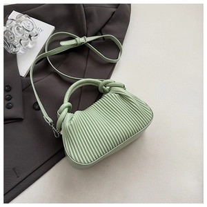 Detail showing mint green ruched texture and knotted handle on this chic tote bag