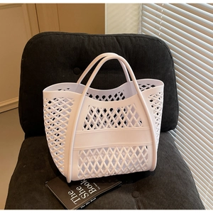 Vue détaillée d'un sac cabas tressé blanc ajouré sur une chaise en velours