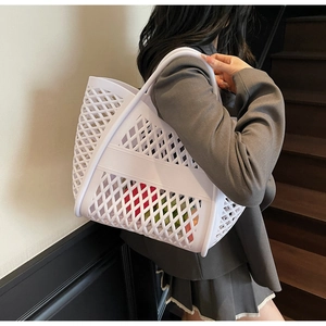 Gros plan d'un grand sac cabas blanc évidé avec un design tressé en forme de losanges