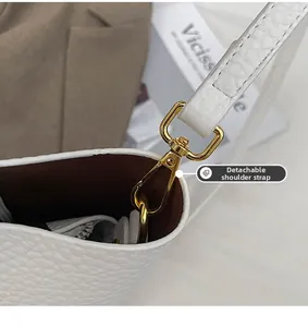 Detail of white lychee leather tote with premium gold lobster clasp and detachable strap