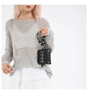 Detail of black pebbled leather mini bag with silver rivets and detachable wristlet strap