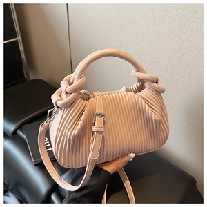 Close-up of pink pleated handbag showing soft texture, cylindrical handle and silver hardware